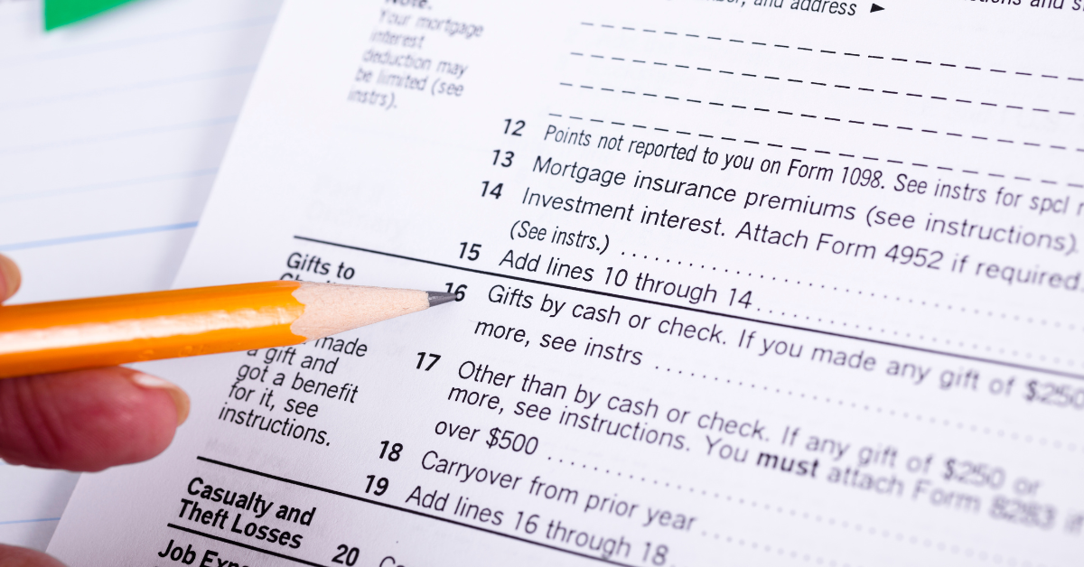 someone filling out tax paperwork with a pencil