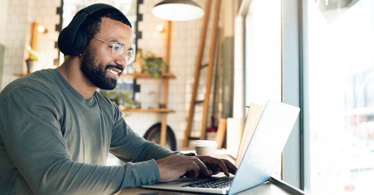 man wearing headphones working on a laptop